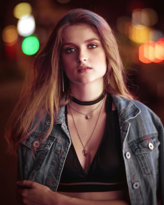 woman with necklace and denim jacket in a black shirt with some lights