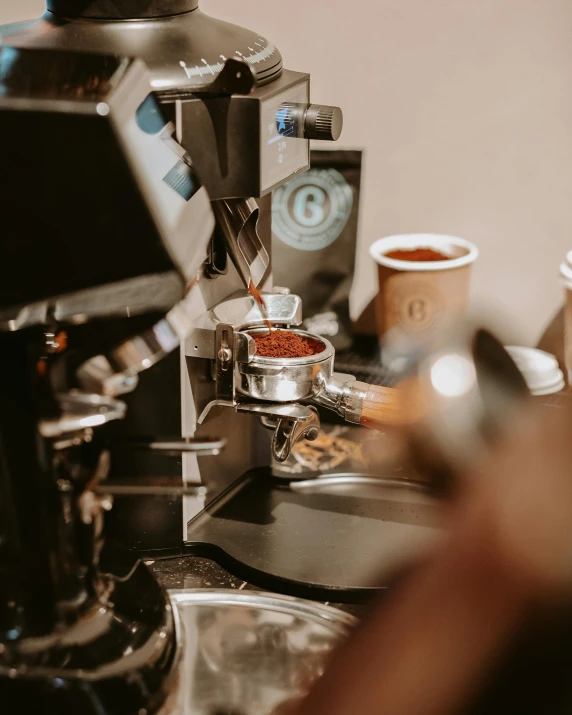 the espresso machine is next to a cup on the counter