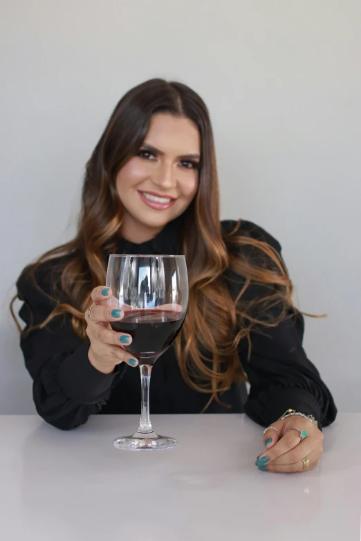 a woman poses with a glass of wine