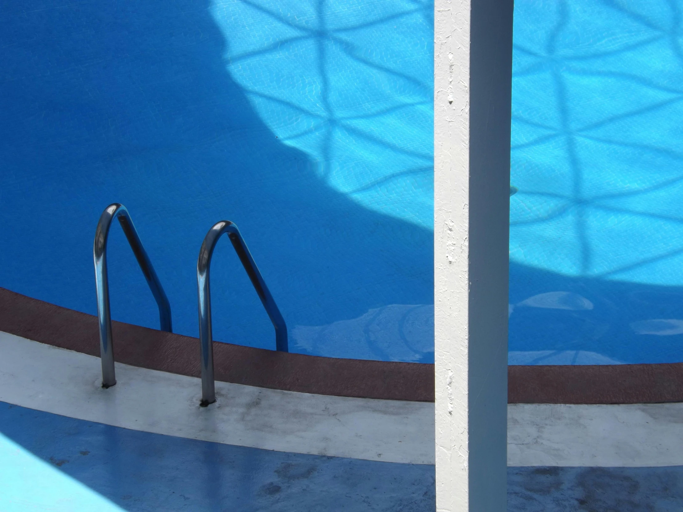 two metal handrails in front of a swimming pool