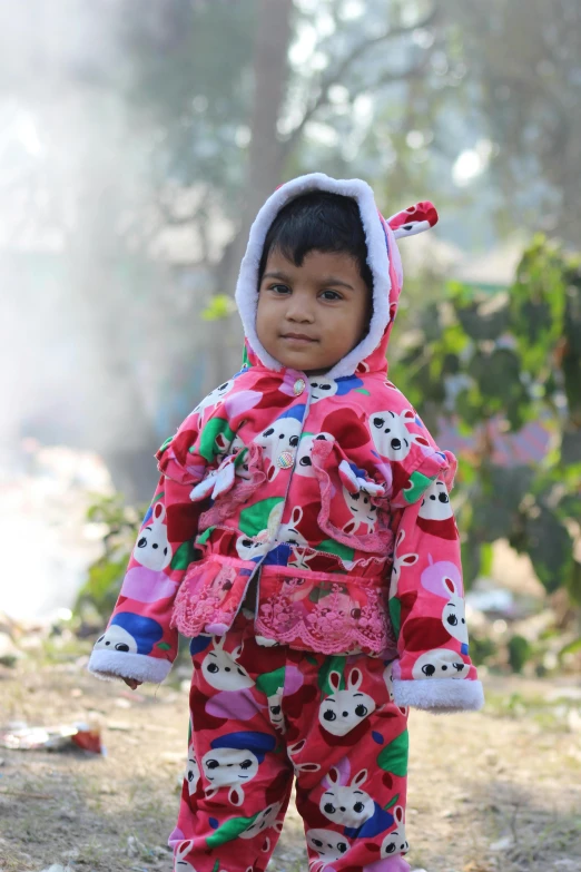 a child wearing a red snowsuit and wearing red shoes