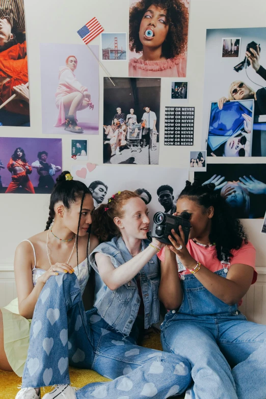 two women sitting on the floor taking pictures in the bedroom