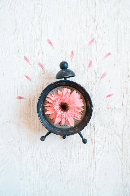 a clock with a pink flower in the middle