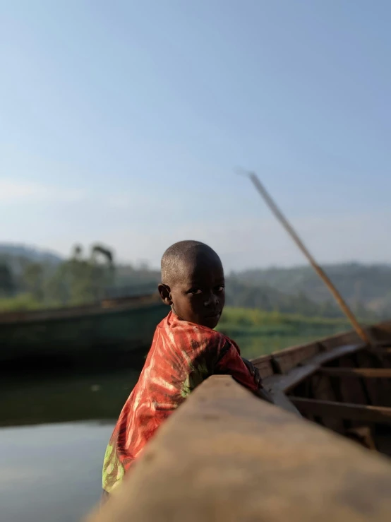 a boy standing next to a body of water