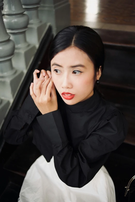 a young woman is sitting down and looking at her hand