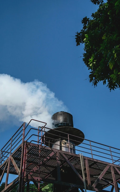 smoke comes from a chimney, and is on top of a metal structure