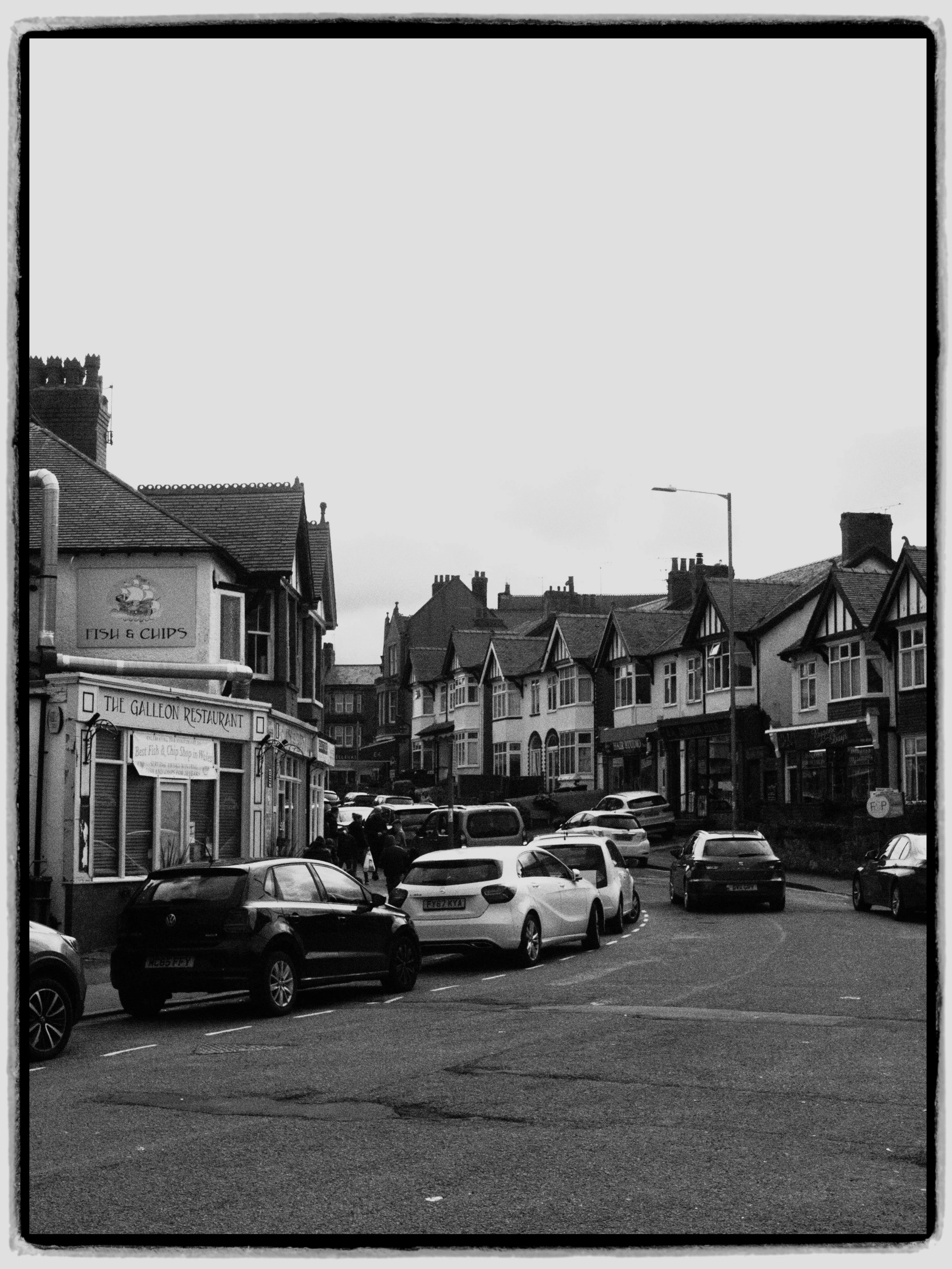 a city street with cars parked in the middle