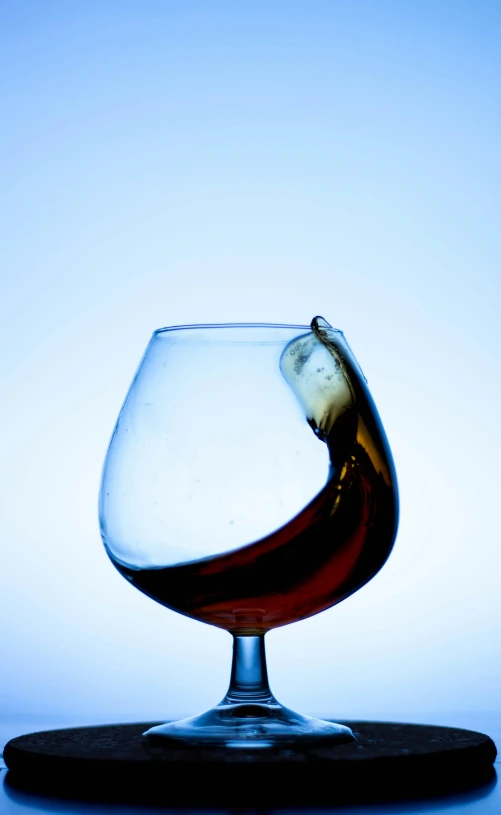 a drink is being poured in a wine glass