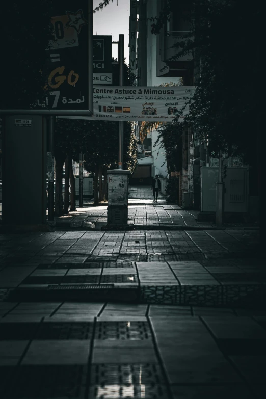 an empty street is shown at night with dark shadows