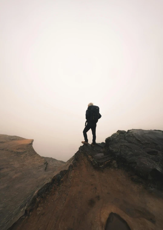 a person with backpack on the top of the mountain