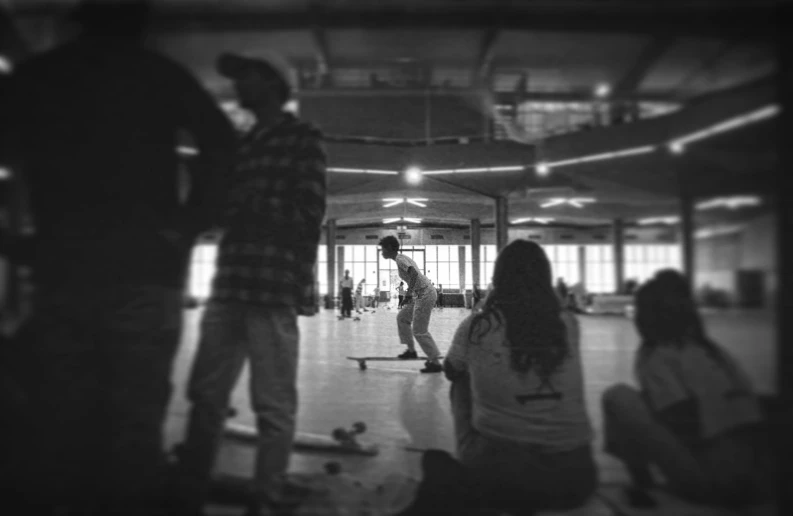 two people are on skateboards inside an indoor area