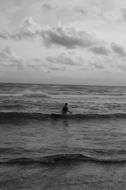 a person sits on their surfboard in the water