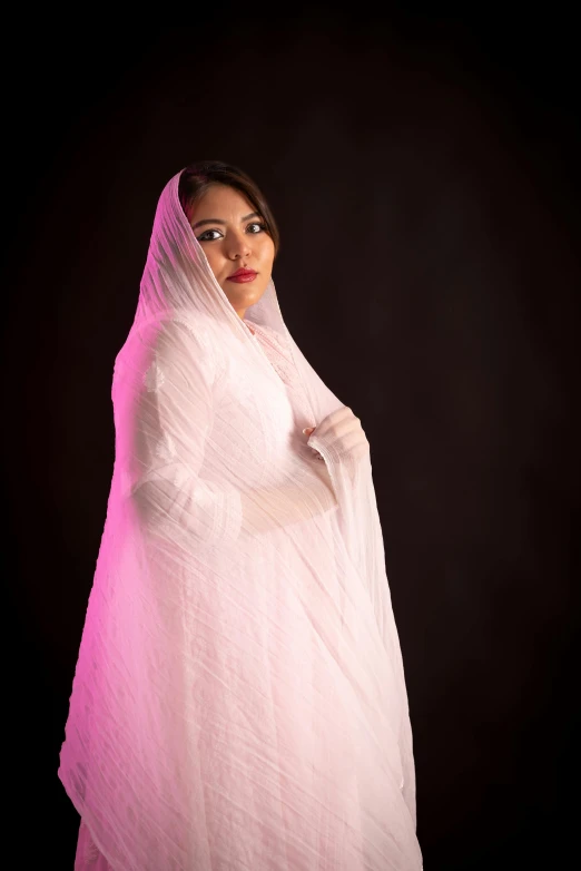 a woman in pink is wearing a veil