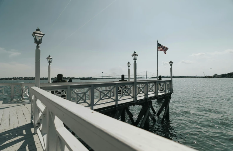 a pier with a flag on it next to the water