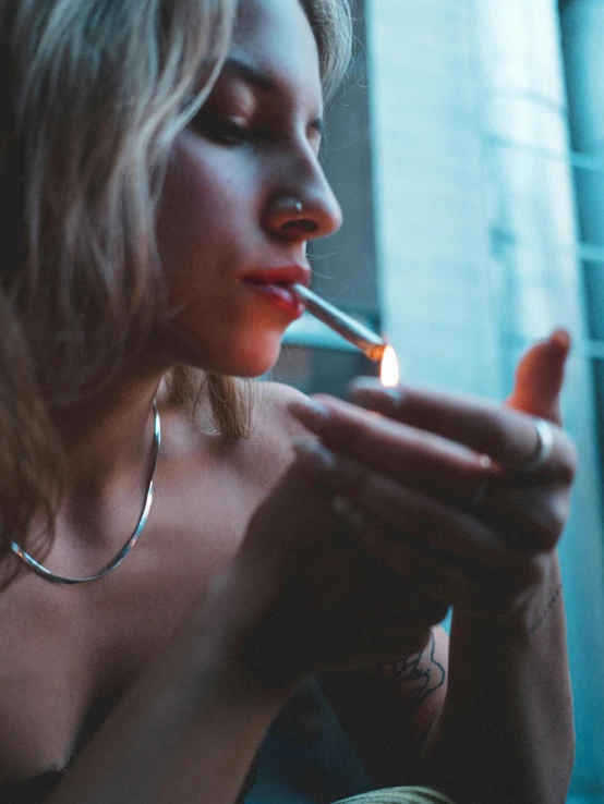 a woman lighting her cigarette on the floor