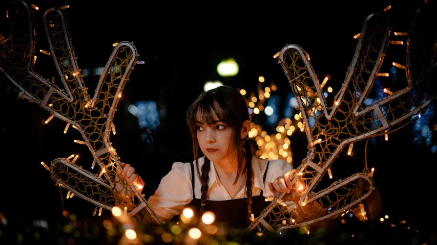 a woman wearing a white top with strings and lights