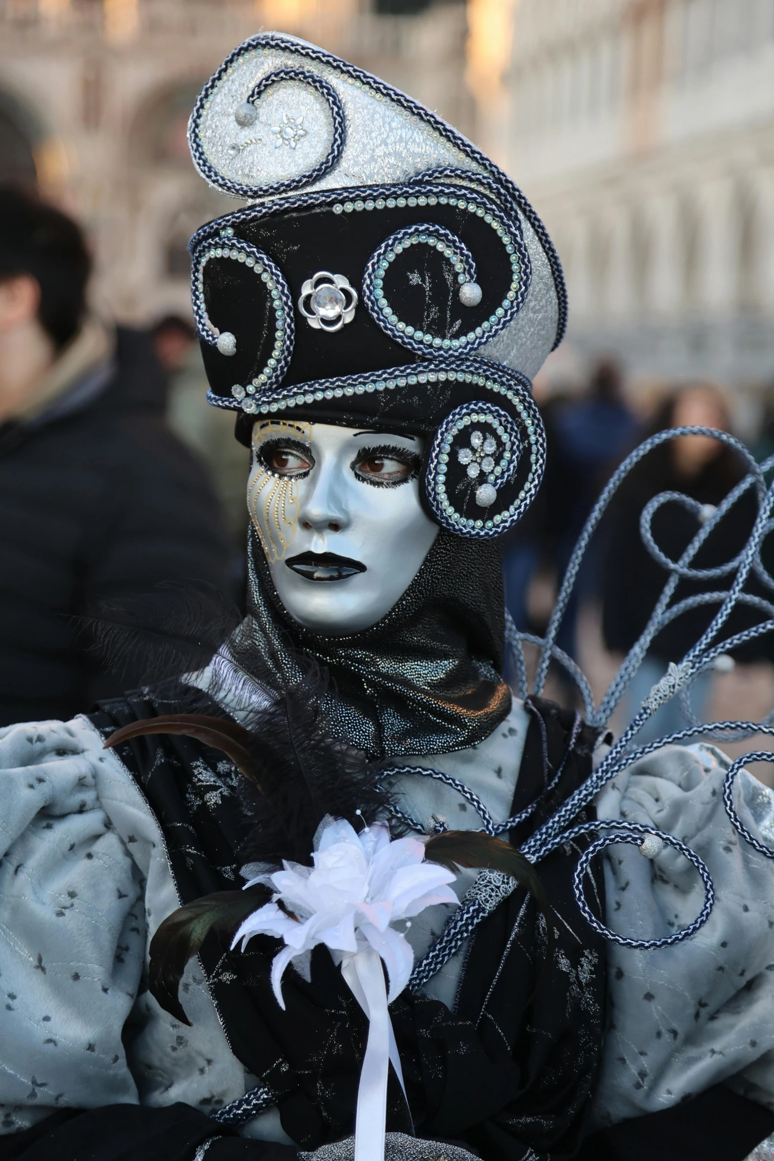 a person wearing fancy garb and hat with many beads