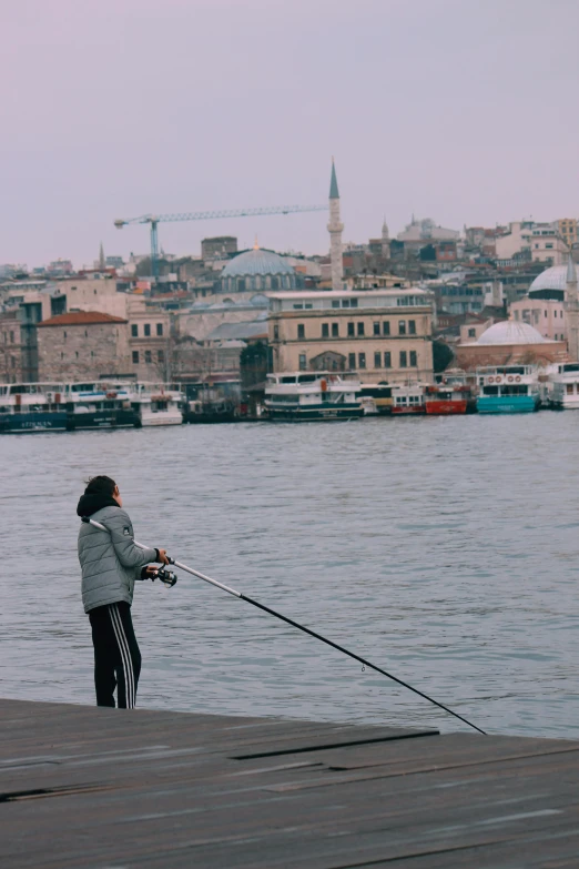 a man with his fishing pole standing on the water