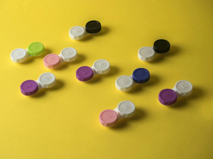 an assortment of colorful pills sitting on a yellow background