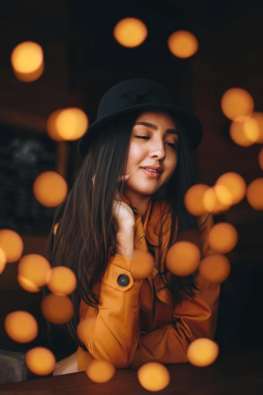 woman with long black hair in hat looking down at phone