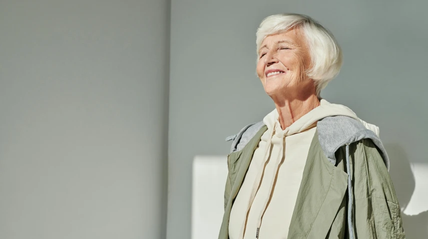 a woman smiling while wearing a green jacket