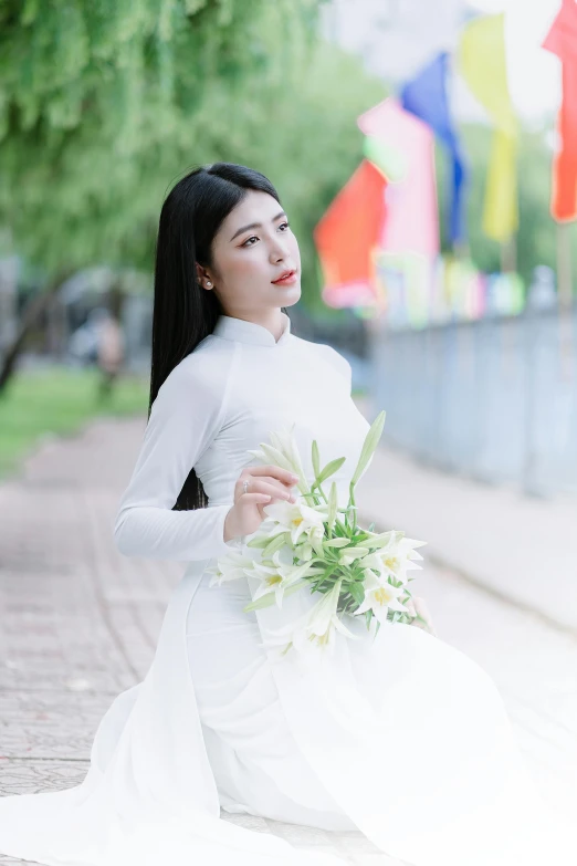 a beautiful woman in white holds a white bouquet