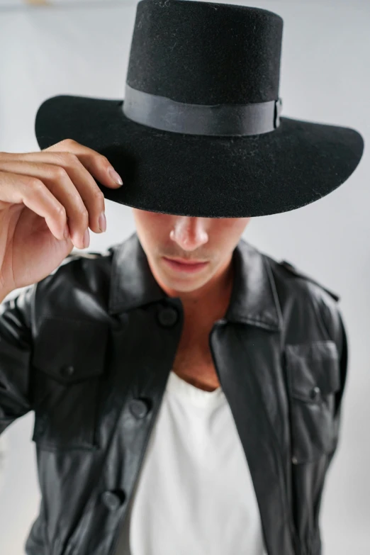 a person wearing a black hat with leather sleeves