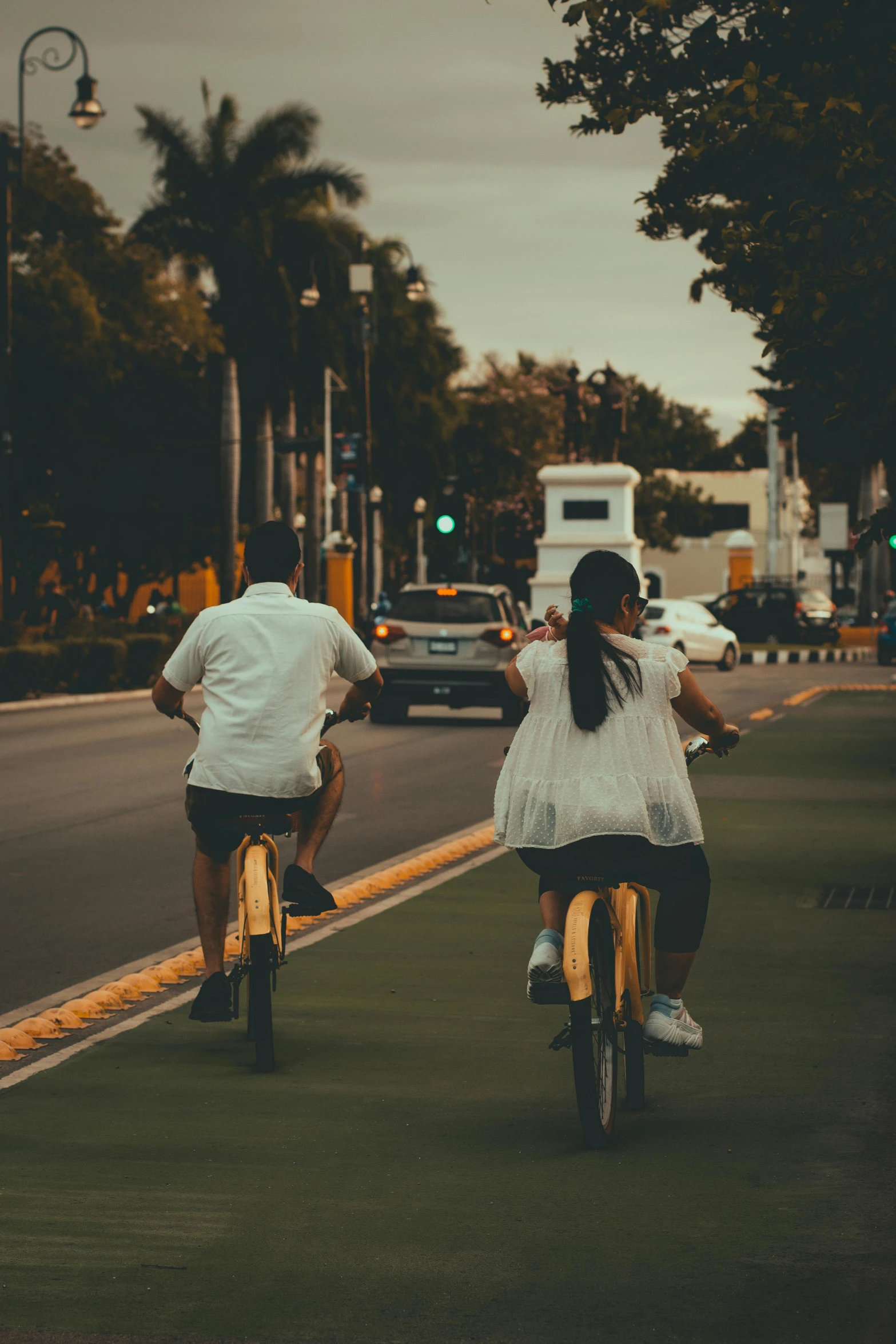 two people riding bicycles on a city street