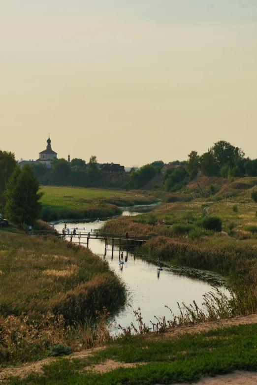 there is a small body of water that goes through an open field