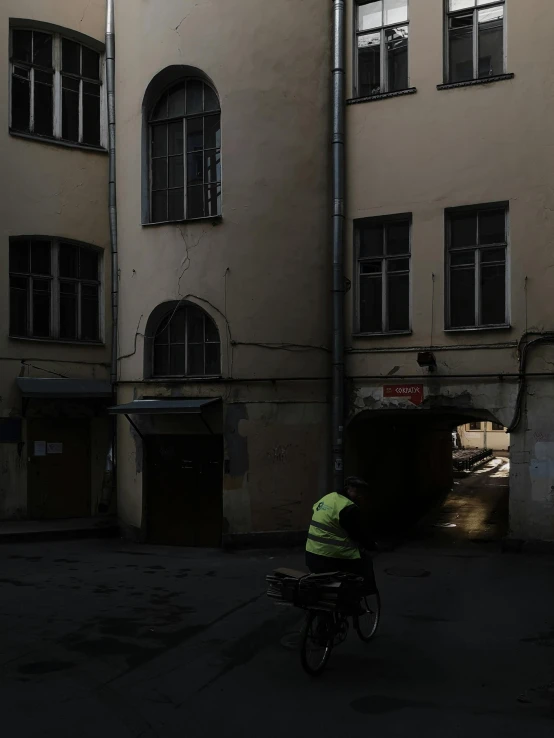 a person riding a bike next to a tall building