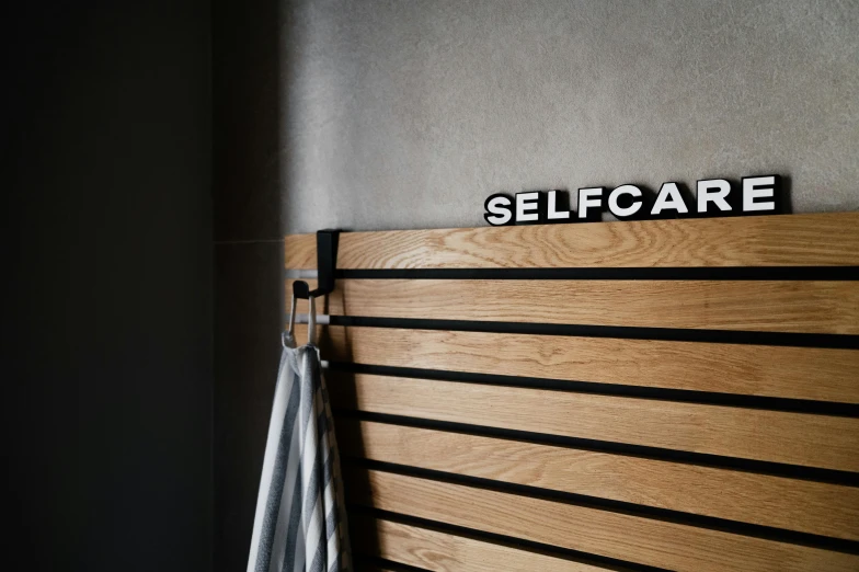an iron and wooden sign on the wall that says self care