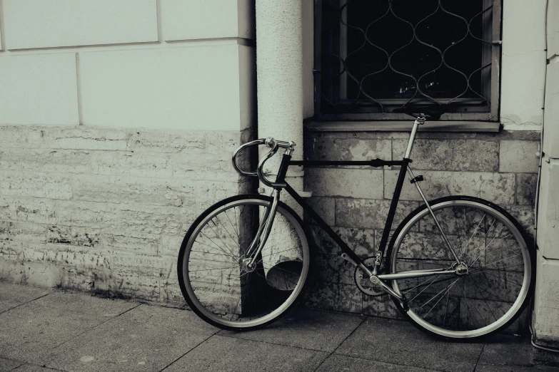 an old black and white po of a bike parked against a wall