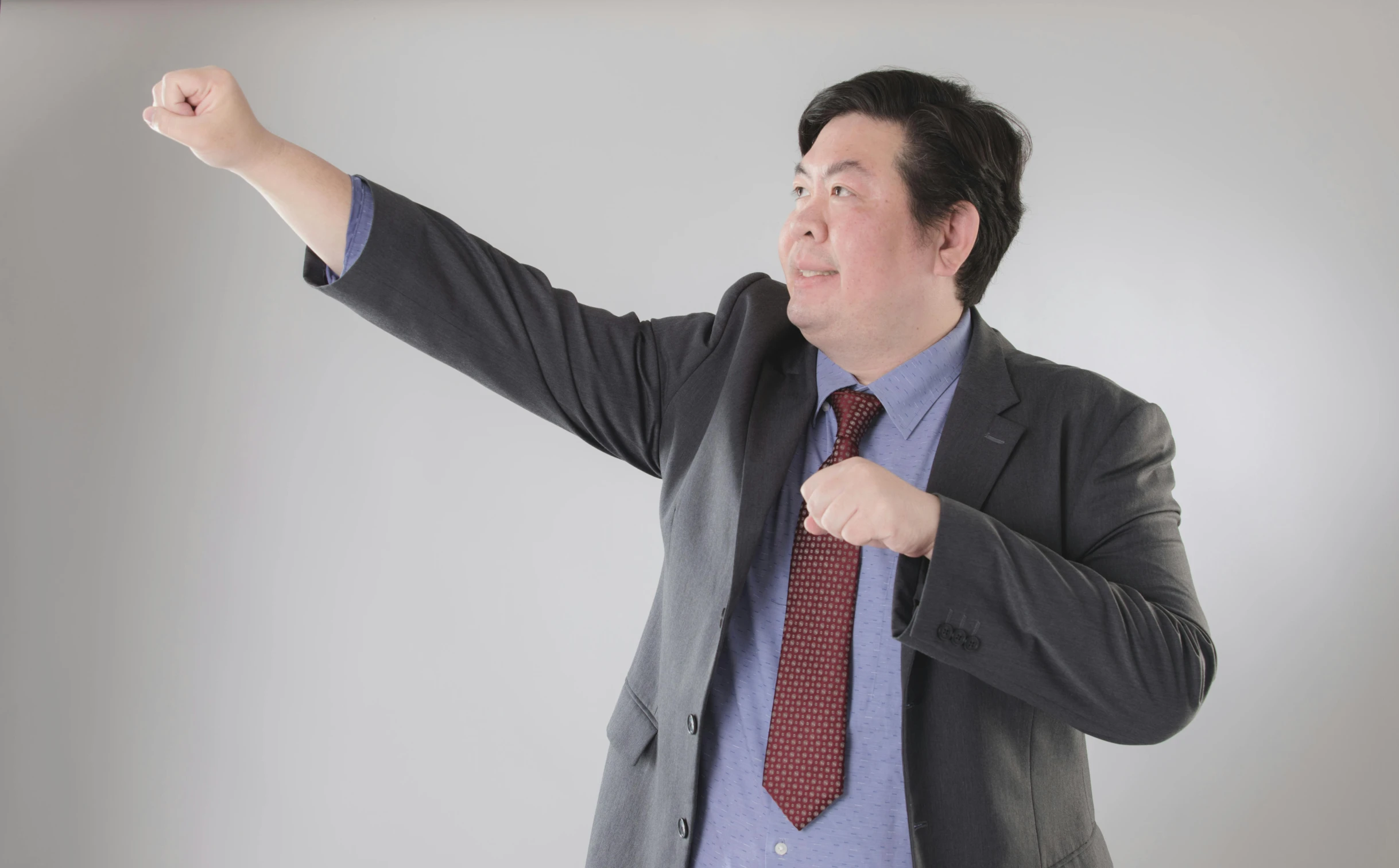 a man in a suit points to the side and points at soing