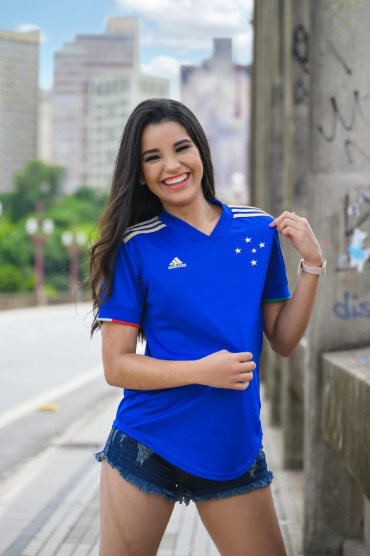 a woman standing in front of a wall posing for the camera