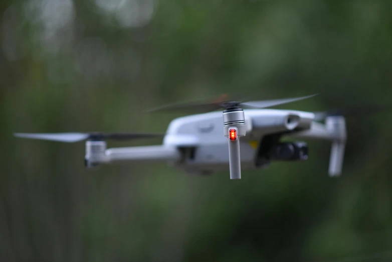 a small gray and red quad rotor is flying in the air