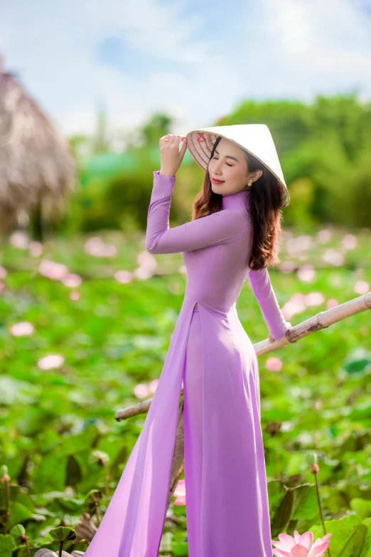 an asian girl wearing a pink dress and straw hat in flowers