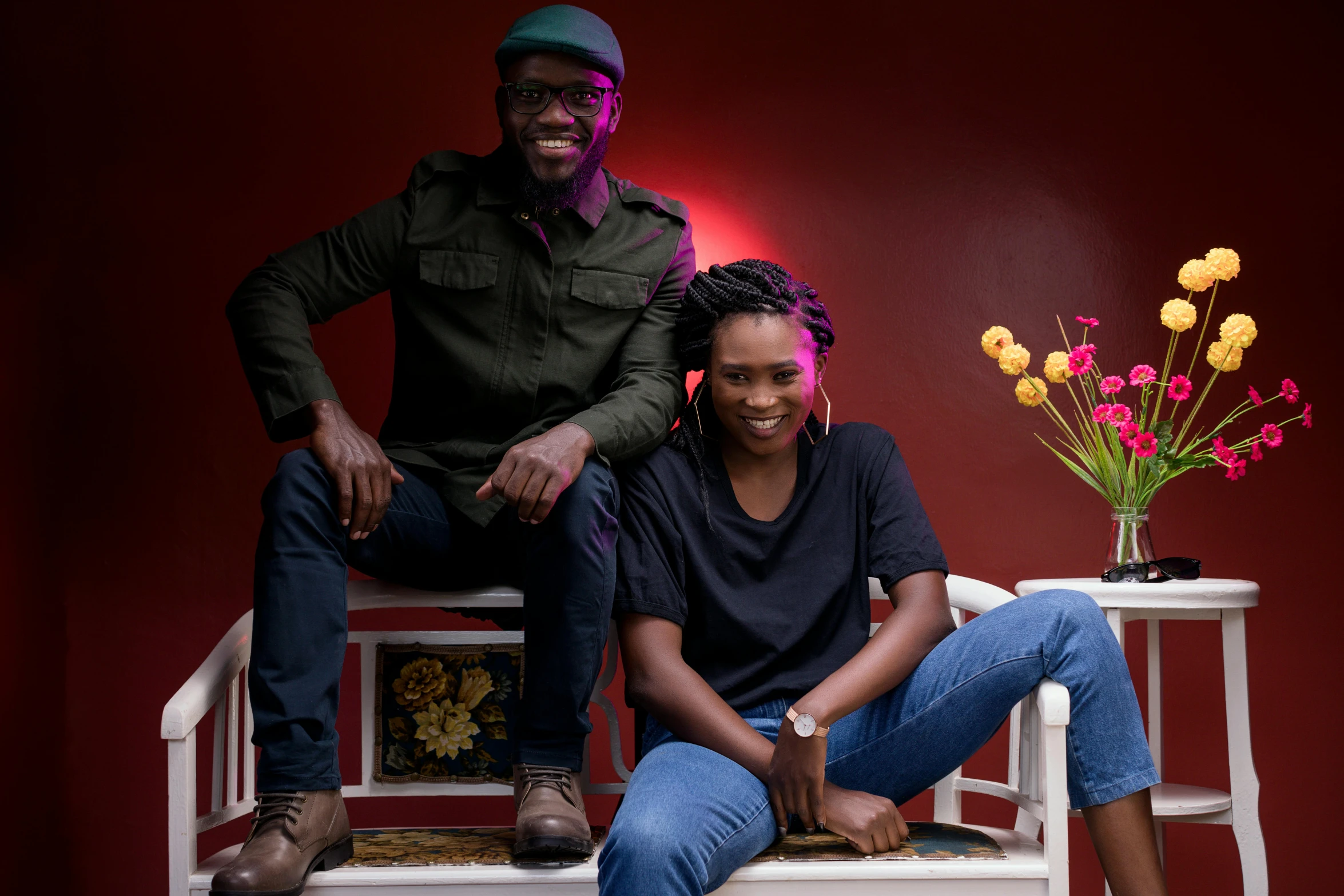 man and woman sitting on a chair with flowers