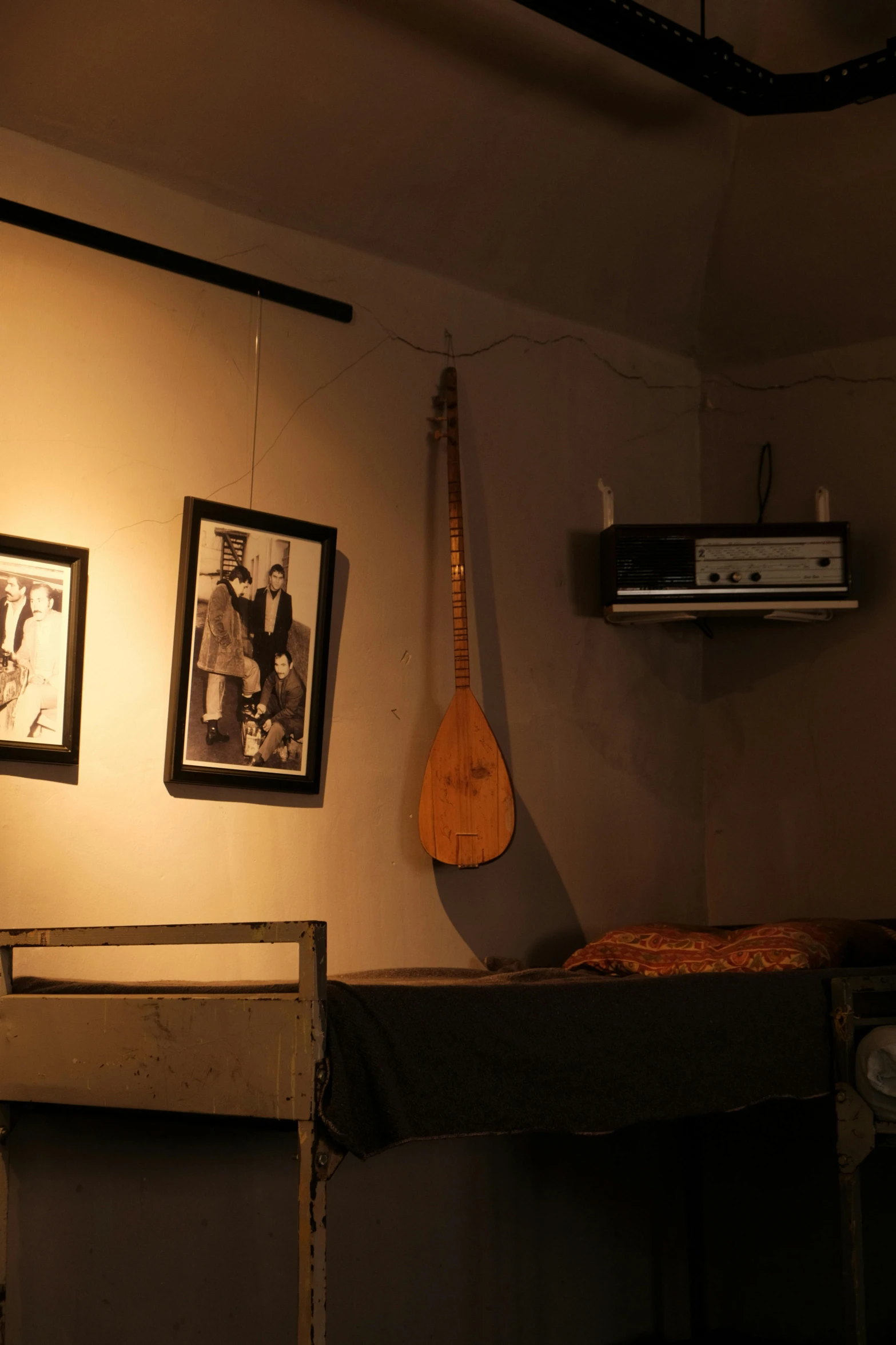 an old guitar hanging on a wall next to pictures