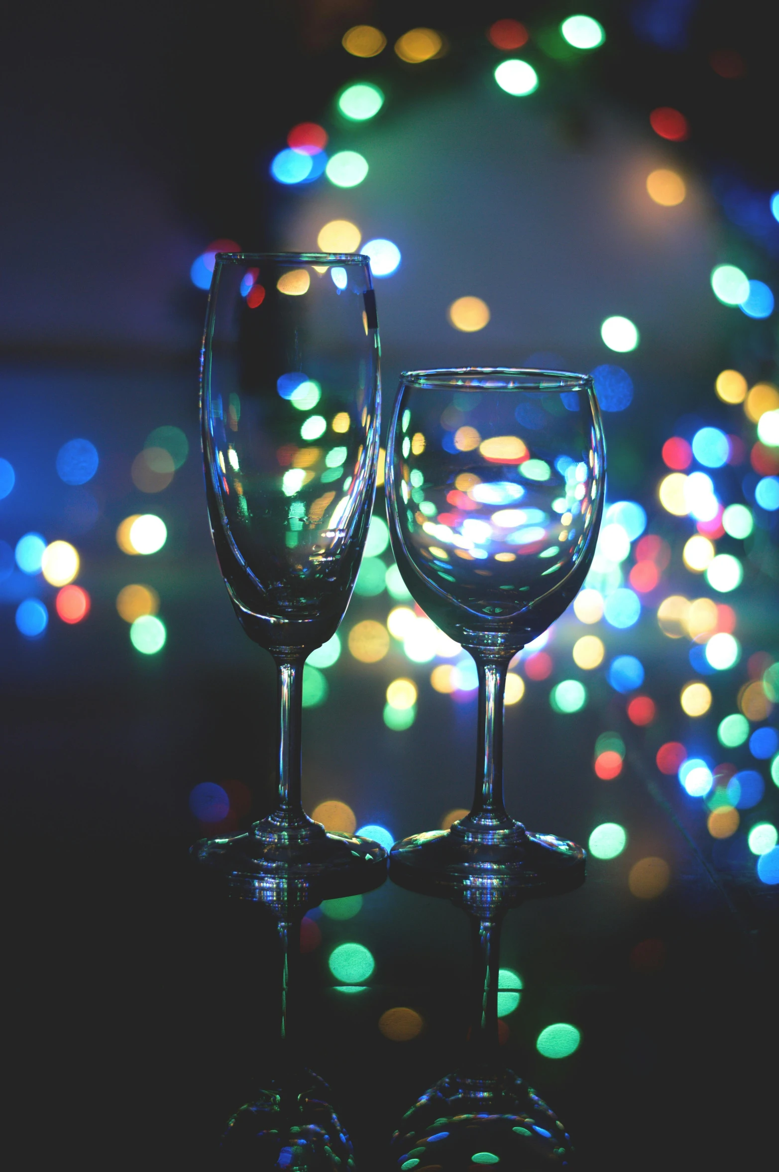 two wine glasses sitting on a glass surface