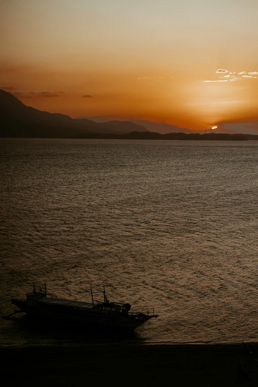 a boat is in the ocean at sunset