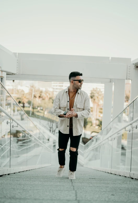 man with sunglasses standing on staircase looking away