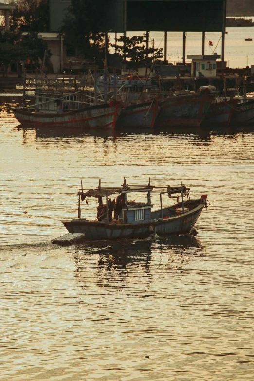 a boat floating down a river next to a marina