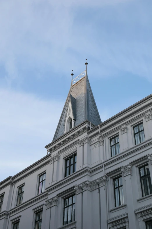 a building with many windows has a steeple on top