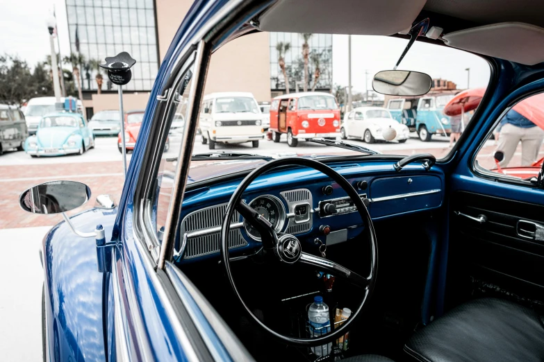 a man driving in an old classic car