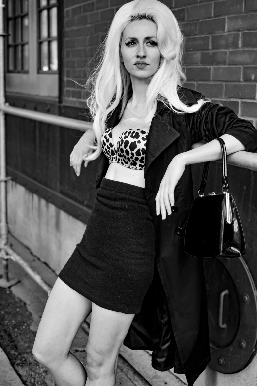 a young blond woman posing in front of a building