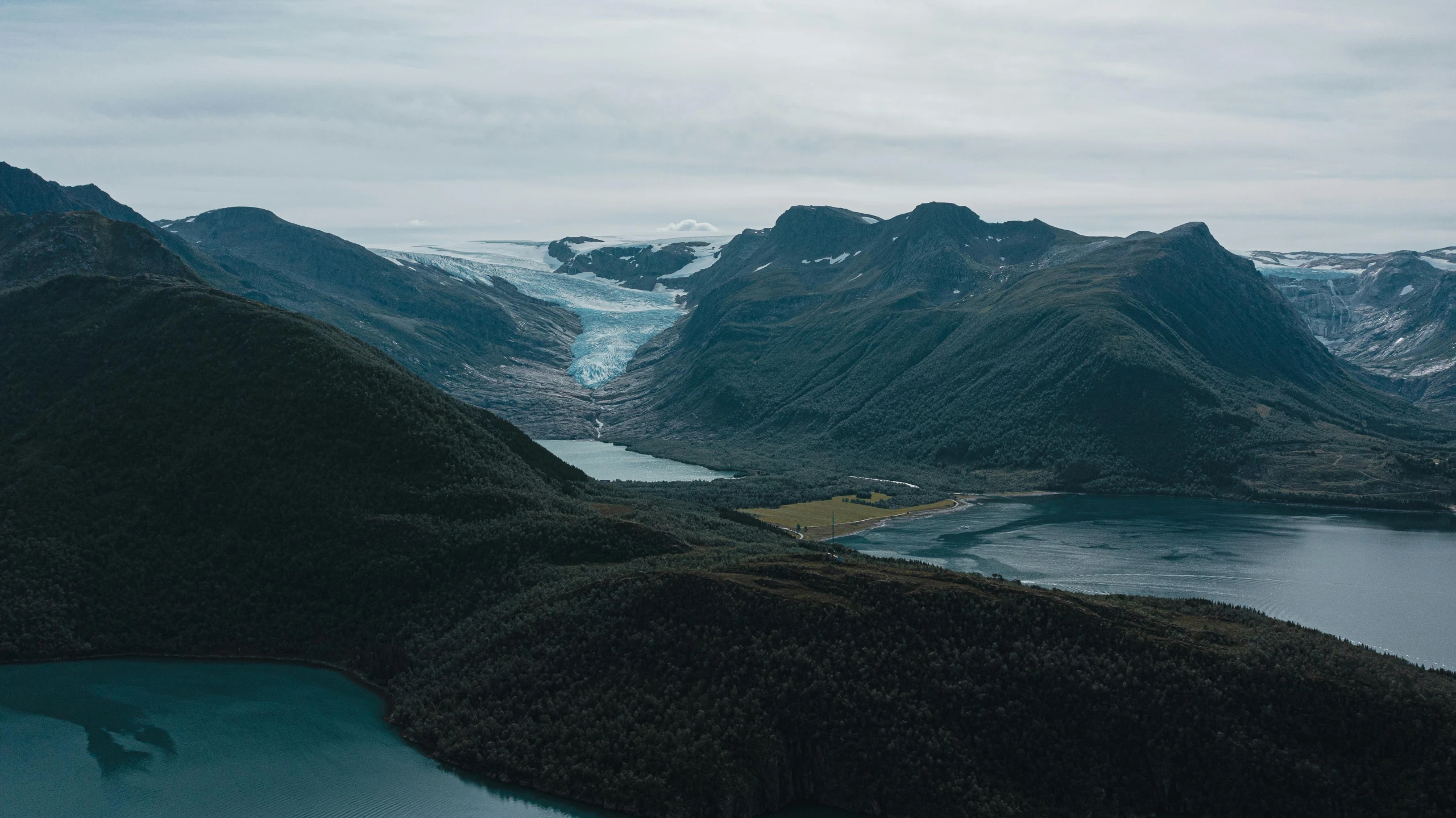 an aerial s of mountains and water near the shore