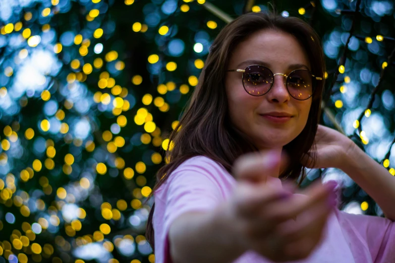 a woman wearing glasses standing in front of some lights
