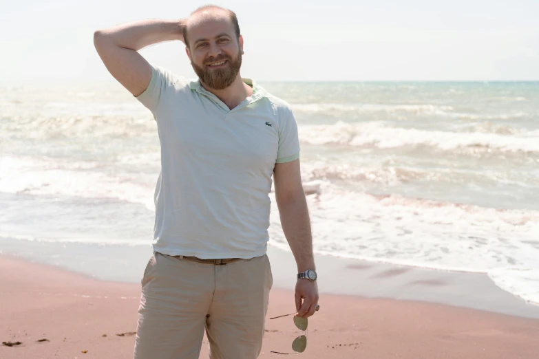 a man is holding his hair up near the beach