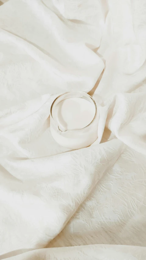 an empty white bowl sitting on top of a bed