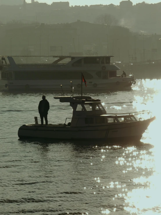the man in black stands on top of a small boat